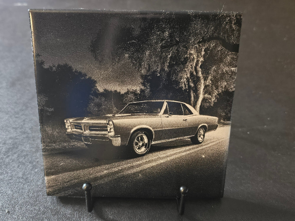 Black and white photo of a classic car on a stand