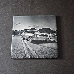  1970 Chevy Chevelle SS on a road with mountains in the background, displayed on a dark surface.