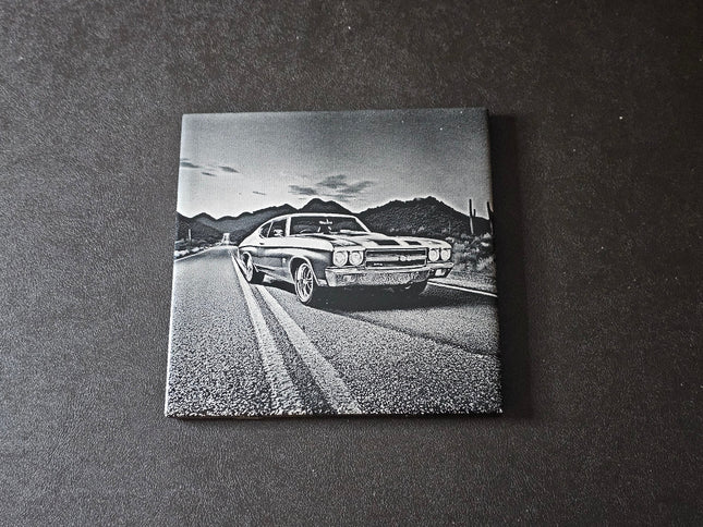  1970 Chevy Chevelle SS on a road with mountains in the background, displayed on a dark surface.