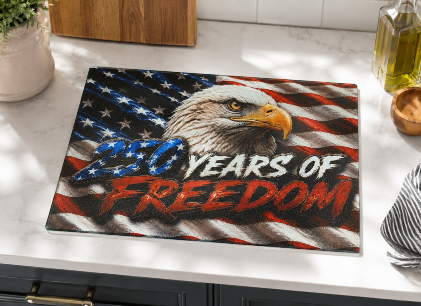 Glass cutting board with American flag design and '250 Years of Freedom' text on a kitchen counter.