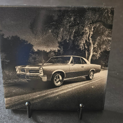 Black and white photo of a classic car on a stand