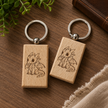 Two wooden keychains with dragon illustrations on a wooden surface.