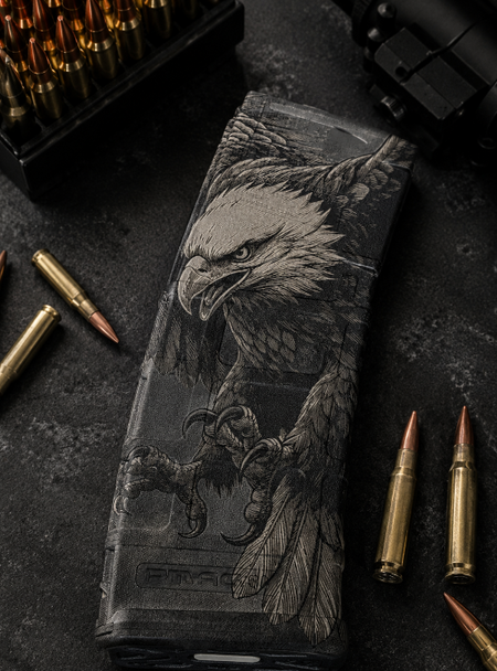 PMAG with an eagle design laser engraved and surrounded by bullets on a dark surface